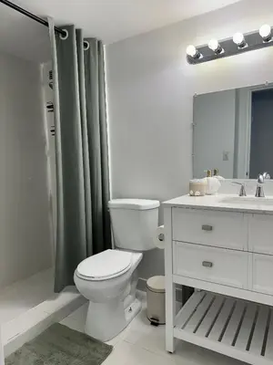 a white bathroom with a toilet and a sink at Pavilion Beach Front Apartment with Balcony in Miami Beach
