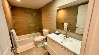 a bathroom with a sink and a toilet and a mirror at Sunny Isles, beach life! Parking included in Miami Beach