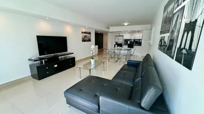 a living room with a couch and a television at Sunny Isles, beach life! Parking included in Miami Beach