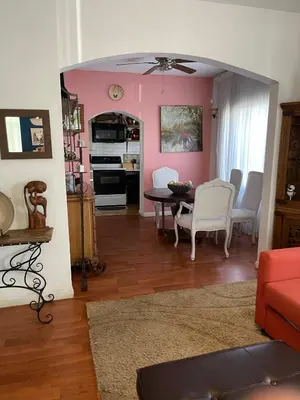 a living room with a table and white chairs at Ne Miami Cottage in Miami