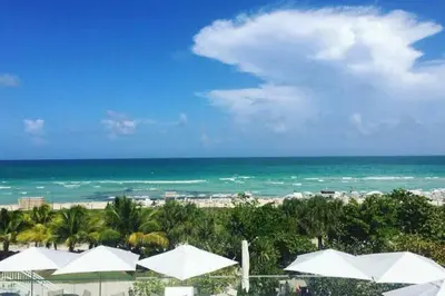 a view of a beach with white umbrellas and the ocean at Incredible Ocean Views! Terrace, 1800 sq.ft., Hotel in Miami Beach