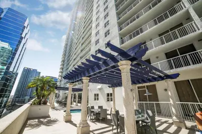 a patio with blue umbrellas in front of a building at Miami Downtown Brickell spacious 4 Bedrooms 6 Beds in Miami