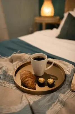 a plate with a cup of coffee and pastry on a bed at Fountain condo 2 story Pool BBQ Balcony in Miami Beach