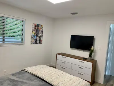 a bedroom with a bed and a flat screen tv at Harbourside Flats in Fort Lauderdale