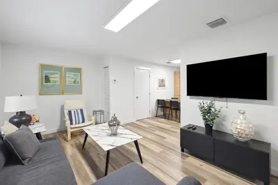 a living room with a flat screen tv on a wall at Harbourside Flats in Fort Lauderdale