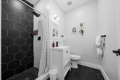 a white bathroom with a shower and a toilet at Nine20 Collins Apartments by Lowkl in Miami Beach