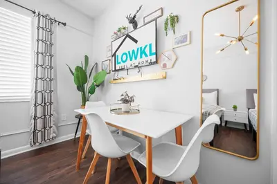 a dining room with a white table and chairs and a mirror at Nine20 Collins Apartments by Lowkl in Miami Beach