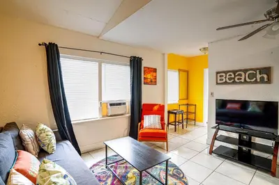a living room with a couch and a television at Little Paris by the ocean self check in in Fort Lauderdale