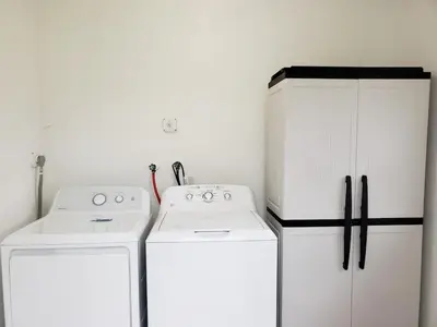 a kitchen with two white appliances and white cabinets at Sophisticated Dania Beach Suites Near the Beach in Dania Beach