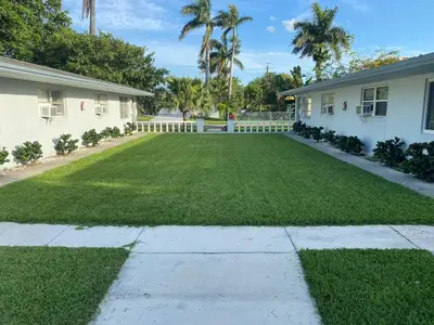 a yard in front of a house with green grass at Sophisticated Dania Beach Suites Near the Beach in Dania Beach