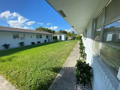 a side view of a house with a yard at Sophisticated Dania Beach Suites Near the Beach in Dania Beach