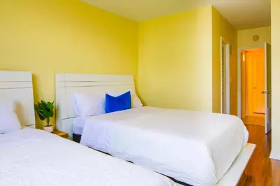 two white beds in a room with yellow walls at Sunny Isles Ocean Reserve Condo Apartments - 1BR #812 in Miami Beach