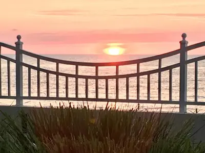 a fence on the beach with the sunset in the background at Apartamento en la Playa The Tides in Hollywood