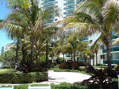a resort with palm trees in front of a building at Apartamento en la Playa The Tides in Hollywood