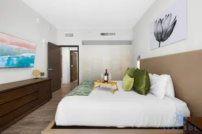 a bedroom with a white bed with a wooden table at Tropical Oasis - Rooftop Pool- Near Beach - Gym in Hollywood