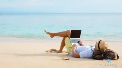 a person laying on the beach with a laptop at Tropical Oasis - Rooftop Pool- Near Beach - Gym in Hollywood