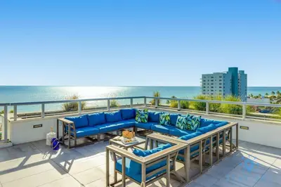 a blue couch on a balcony overlooking the ocean at Rooftop Pool - Hollywood Beach Boardwalk in Hollywood