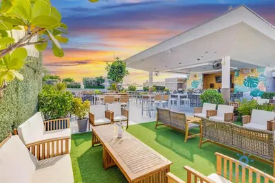 an outdoor patio with tables and chairs and a sunset at Near Beach - Rooftop Pool - Hot Tub - Broad-walk in Hollywood