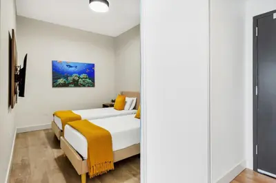a bedroom with two beds and a mirror at Ocean View - Balcony - Hollywood Beach Broad-walk in Hollywood