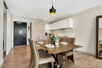 a kitchen and dining room with a wooden table and chairs at Ocean View - Balcony - Hollywood Beach Broad-walk in Hollywood