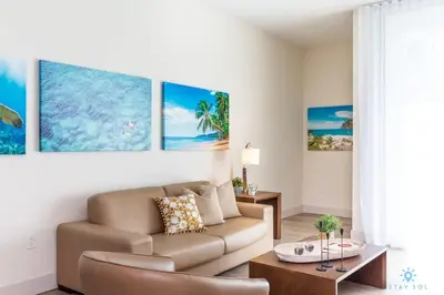 a living room with a couch and a table at NEW!Beachfront Condo Resort- Balcony in Hollywood