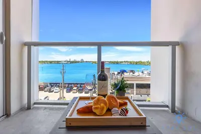 a table with a bottle of wine and a plate of food at Bay View - Rooftop Pool - Hollywood Beach Broad -walk in Hollywood