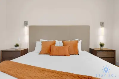 a bedroom with a white bed with orange pillows at Bay View - Rooftop Pool - Hollywood Beach Broad -walk in Hollywood