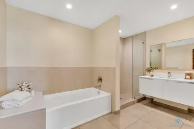 a white bathroom with a tub and a sink at Beachfront Condo-ROOFTO POOL- 2 BEDROOMS 2 BR ! in Hollywood
