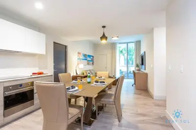 a kitchen and dining room with a table and chairs at NEW LUXURY Beachfront Condo Resort in Hollywood