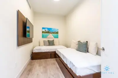 two beds in a room with white walls at NEW LUXURY Beachfront Condo Resort in Hollywood