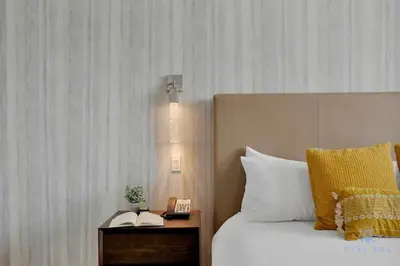 a bedroom with a bed and a nightstand with a phone at Best Stay - Rooftop Pool & Hot Tub - Hollywood Beach in Hollywood