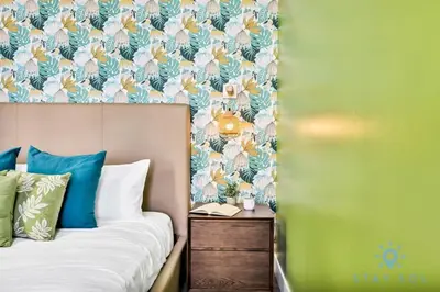 a bedroom with a bed with a floral wallpaper at Costa Hollywood - Worth Traveling - Rooftop Pool- Gym in Hollywood