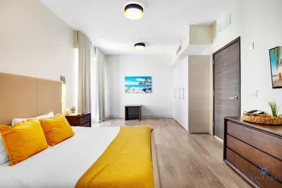 a bedroom with a large bed with yellow pillows at Bay View - Balcony - Amazing Pool - Hollywood Beach in Hollywood