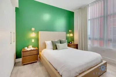 a bedroom with a large bed with a green wall at Lx Oasis Beachfront-Rt infinity POOL in Hollywood