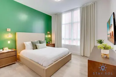 a bedroom with a bed and a green wall at Lx Oasis Beachfront-Rt infinity POOL in Hollywood