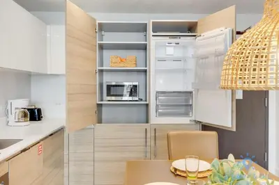 a kitchen with white cabinets and a table in it at Rooftop Pool & Hot Tub - Gym - Hollywood Beach in Hollywood