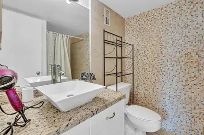 a bathroom with a white sink and a toilet at Lovely apartment in the heart of South Beach in Miami Beach