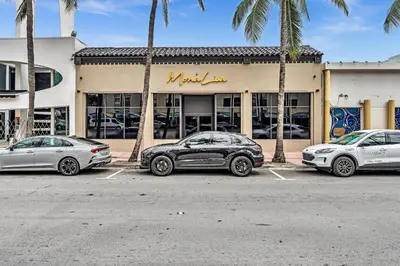 three cars parked in a parking lot in front of a store at Lovely apartment in the heart of South Beach in Miami Beach