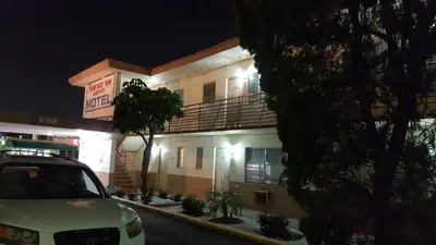 a white car parked in front of a building at night at Parkway Inn in Miami