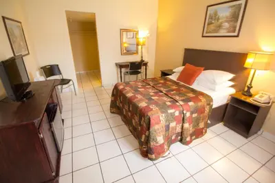 a hotel room with a bed and a television at Parkway Inn in Miami
