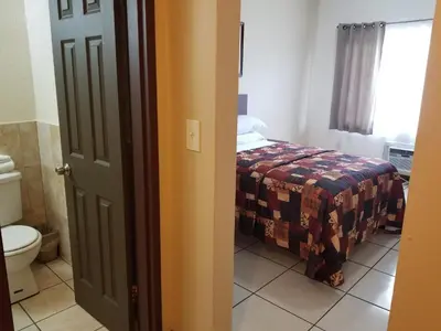a bathroom with a bed and a toilet in a room at Parkway Inn in Miami