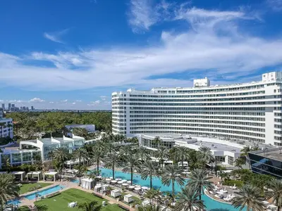 a large white building with a pool and palm trees at Studio at Sorrento Residences- FontaineBleau Miami Beach home in Miami Beach