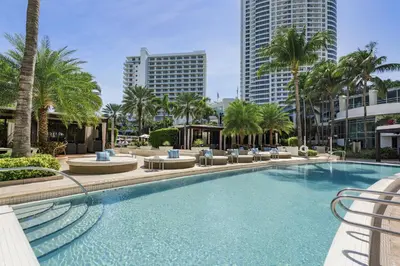 a large swimming pool with palm trees and buildings at Studio at Sorrento Residences- FontaineBleau Miami Beach home in Miami Beach