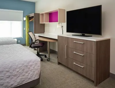 a hotel room with a bed and a desk with a television at Home2 Suites By Hilton Ft. Lauderdale Downtown, Fl in Fort Lauderdale