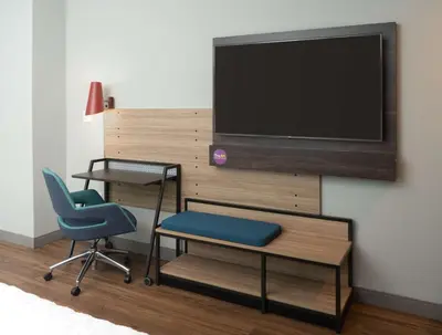 a room with two chairs and a television on a wall at Tru By Hilton Fort Lauderdale Downtown-Flagler Village in Fort Lauderdale