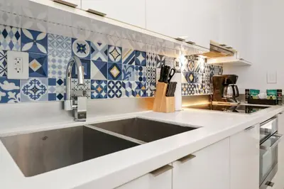 a kitchen with a sink and blue and white tiles at Roami at 250 Collins in Miami Beach