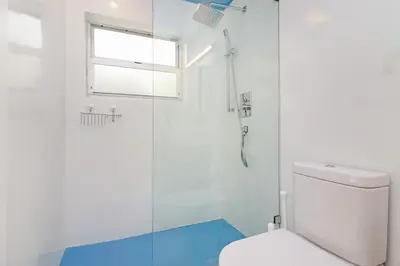 a white bathroom with a shower and a toilet at Roami at 250 Collins in Miami Beach