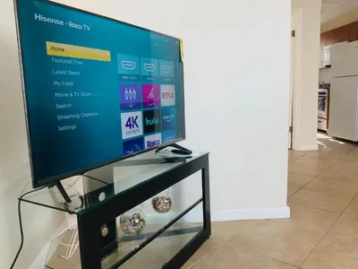 a flat screen tv sitting on top of a tv stand at Hollywood Beach Apartments - Walk to the Beach in Hollywood
