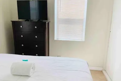 a bedroom with a bed and a dresser with a roll of paper towels at Hollywood Beach Apartments - Walk to the Beach in Hollywood