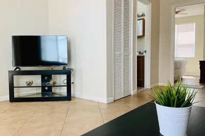 a living room with a flat screen tv on a stand at Hollywood Beach Apartments - Walk to the Beach in Hollywood